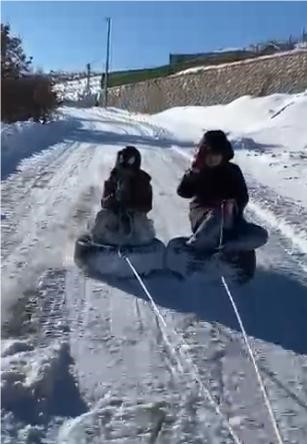 Lastiği kızak yapıp araçla çektiler: Çocukların kar eğlencesi kameralara yansıdı