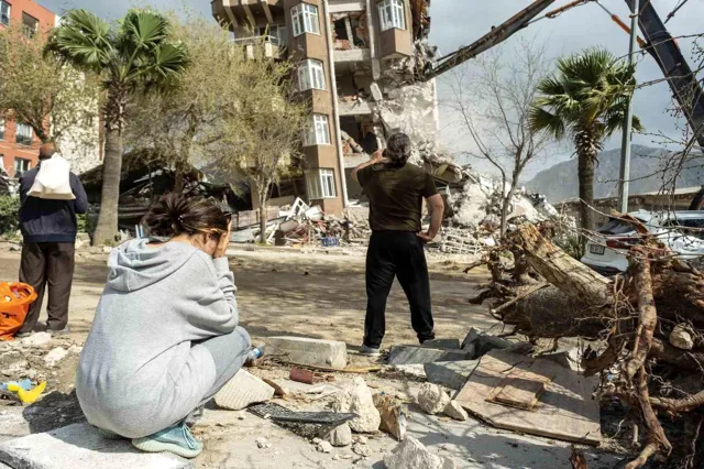 Yağmur sayesinde kurtulduğu binanın yok oluşunu gözyaşlarıyla izledi