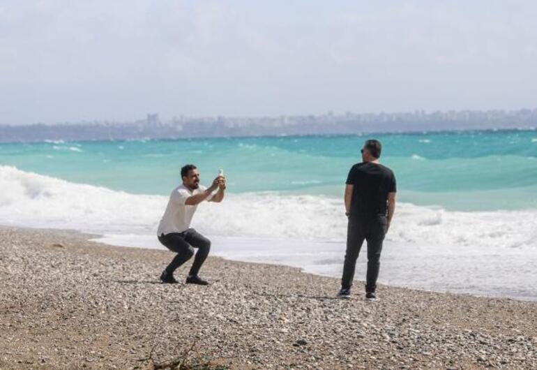 Rüzgarlı havada sahilde dalgalarla fotoğraf çektirdiler