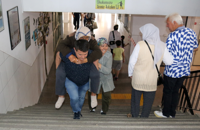 Yardım isteyen 90 yaşındaki kadını oy kullanmaya sırtında götürdü